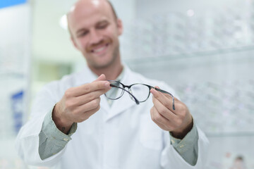 Wall Mural - male ophthalmologist with eyeglasses in clinic, closeup. Space for text