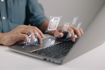 Leinwandbilder - Businessman holding a laptop with a document management icon in it while utilizing the data system for business on the internet.