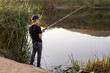 © OSProjects - Boy fishing at the pond in the evening