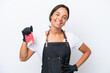 © luismolinero - Butcher hispanic woman wearing an apron and serving fresh cut meat isolated on white background posing with arms at hip and smiling