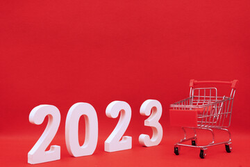 2023 number with Red Gift Box in shopping cart on red pattern background - End of year 2022 and Happy new year 2023 concept - Online Shopping Box , Marketing promotion advertise design - holiday