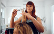 © K Abrahams/peopleimages.com - Hairdresser, salon and haircut, woman and hair, comb and scissors for beauty and hair care service. Beautician, entrepreneur and small business, hairstyle and stylist with client for grooming.