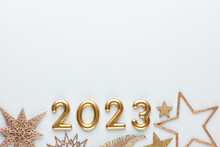 New Year 2023 Number, Golden Digits And Santa Hat Over Blue Background.
