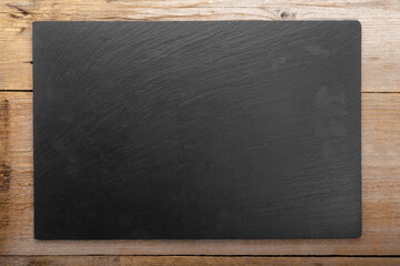 Wall Mural - Empty cutting slate board on planks food background concept.