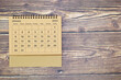 © Alessandro - Top view of new year calendar January 2023 of yellow straw color on old wooden background with negative space on the right.