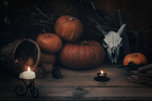 Samhain Magic Altar. Pumpkins, Goats Skull, Burning Candles, Dry Herbs And Rotten Apples On Wooden Background, Selective Focus.