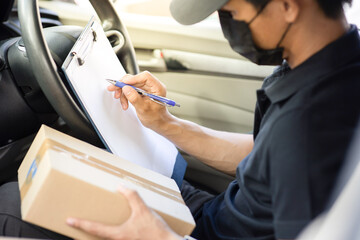 The courier checks the correctness of the parcel box. before delivering the product to the customer in the car.