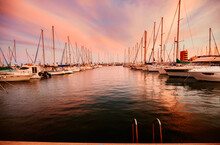 Masted Yachts Moored In Marina At Sunset