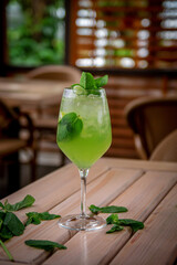 Alcoholic refreshing cocktail Hugo Spritz with ice cubes, on the summer terrace of the restaurant. Summer Italian aperitif made with Prosecco sparkling wine, lime, mint and elderflowers syrup