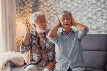 Man shouting and talking to woman tired thinking on separation covering her ears..