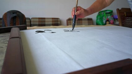 Wall Mural - an old calligrapher is writing calligraphy characters, creating calligraphy works. translation: the 
