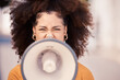© Anela R/peopleimages.com - Megaphone, speaker and black woman leading a street protest for change, equality and democracy. Noise, politics and unemployment crisis with frustrated female taking action, demand government help