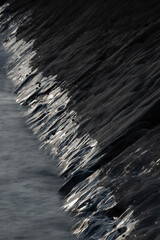Wall Mural - Abstract landscape picture of rocks on Welcome Mouth Beach at sunset with tide marks on rocks reflecting sunlight