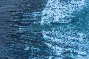 Wall Mural - Aerial drone landscape bird's eye view of vibrant sunset over Welcombe Mouth Beach in Devon England with waves crashing on rocks