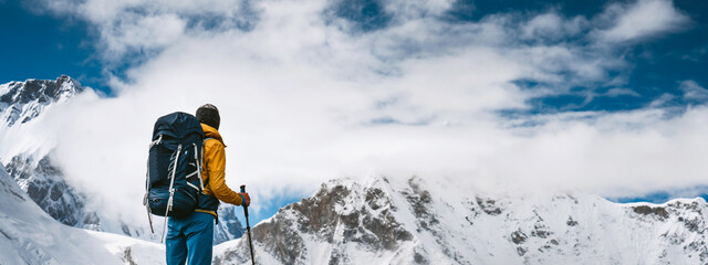 Man hiker going mountain track. Solo traveling with touristick backpack across mountains