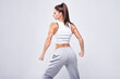 © andy_gin - Young white fitness woman wearing sportswear standing over white wall background. Fitness concept