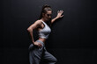 © andy_gin - Athletic fitness woman posing in the studio on a dark background. Photo of an attractive woman in fashionable sportswear. Sports and healthy lifestyle