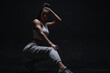 © andy_gin - Athletic fitness woman posing in the studio on a dark background. Photo of an attractive woman in fashionable sportswear. Sports and healthy lifestyle