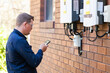 © Austockphoto - Electrician using mobile phone device to troubleshoot