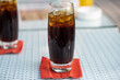 Ein Glas Cola auf einem roten Untersetzer