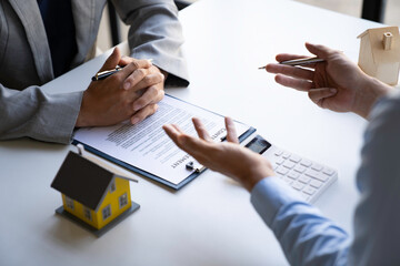 Wall Mural - Business people negotiating a contract, Close up Businessmen or Real Estate agents explain signing the agreement for buying the house. The bank manager and real estate