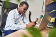© baranq - Distracted employee looking using mobile phone while working at office