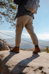 Poster - hiking concept men legs in boots on the rock