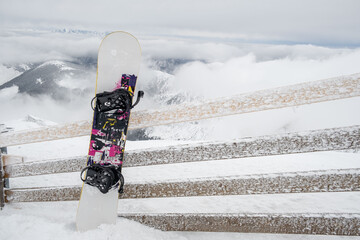 snowboard stick in snow mountains on background