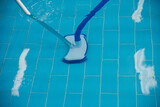 Fototapeta Kuchnia - Cleaning the pool. A man cleans the pool