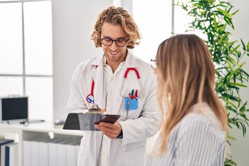 Canvas Print - Man and woman doctor and patient having medical consultation write on document at clinic