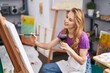© Krakenimages.com - Young blonde woman artist drinking wine drawing at art studio