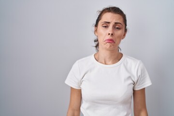 Canvas Print - Beautiful brunette woman standing over isolated background depressed and worry for distress, crying angry and afraid. sad expression.