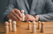 © Looker_Studio - HR manager hand or Employer chooses takes in hand employee. Leader stands out from crowd. Looking for good worker. HR, HRM, HRD concepts.