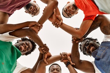 Sticker - Group of young african american artist man smiling happy doing form with arms at art studio.