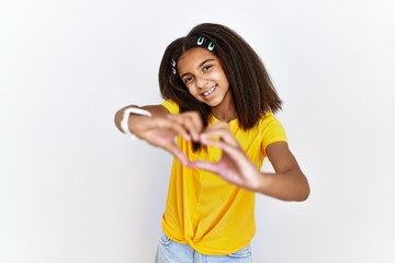 Poster - Young african american girl standing over white isolated background smiling in love doing heart symbol shape with hands. romantic concept.