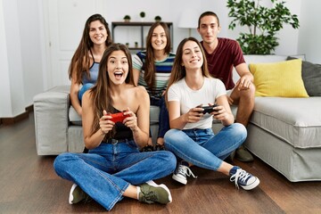 Poster - Group of young friends smiling happy playing video game at home.