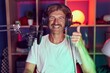 © Krakenimages.com - Caucasian man with mustache playing video games wearing headphones smiling happy and positive, thumb up doing excellent and approval sign