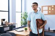 African american man business worker smiling confident holding leather briefcase at office