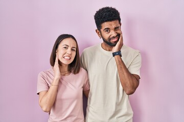 Sticker - Young hispanic couple together over pink background touching mouth with hand with painful expression because of toothache or dental illness on teeth. dentist concept.