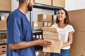 Sticker - Man and woman business partners smiling confident holding packages at storehouse