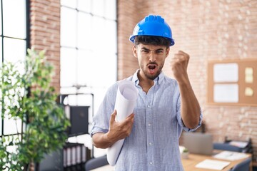 Canvas Print - Arab man with beard wearing architect hardhat at construction office annoyed and frustrated shouting with anger, yelling crazy with anger and hand raised