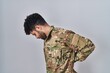 © Krakenimages.com - Arab man wearing camouflage army uniform suffering of backache, touching back with hand, muscular pain