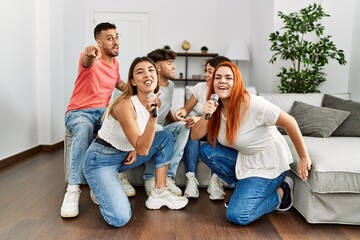 Sticker - Group of young friends having party singing song using microphone at home.