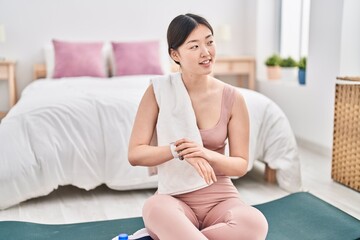 Poster - Chinese woman wearing sportswear looking watch at bedroom