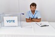 © Krakenimages.com - Young handsome man at political election sitting by ballot skeptic and nervous, disapproving expression on face with crossed arms. negative person.
