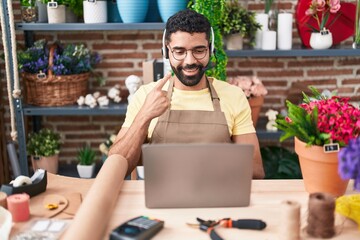 Sticker - Hispanic man with beard working at florist shop doing video call smiling happy pointing with hand and finger