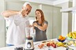 © Krakenimages.com - Middle age hispanic couple pouring water on mixer machine cooking smoothie at the kitchen.