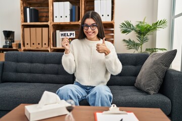 Poster - Young hispanic woman going to therapy at consultation office asking for help smiling happy and positive, thumb up doing excellent and approval sign