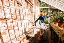 Girl Dancing In A Green House In The Sunshine
