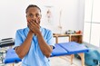 © Krakenimages.com - Black woman with braids working at pain recovery clinic shocked covering mouth with hands for mistake. secret concept.